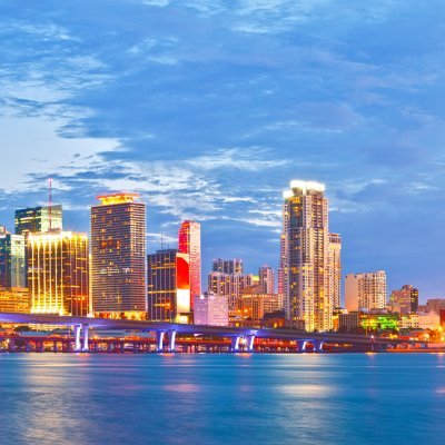 Miami Florida at sunset, cityscape of modern downtown buildings illuminated with reflections in the waters of Biscayne BAy