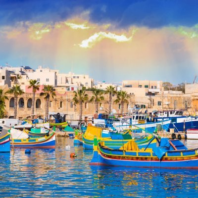 Marsaxlokk village harbor of Malta, illuminate by sunset light