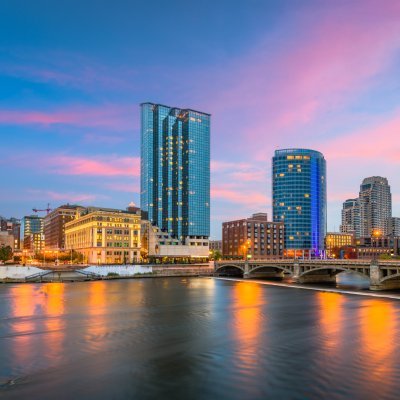 Grand Rapids, Michigan, USA downtown skyline on the Grand River at dusk.
